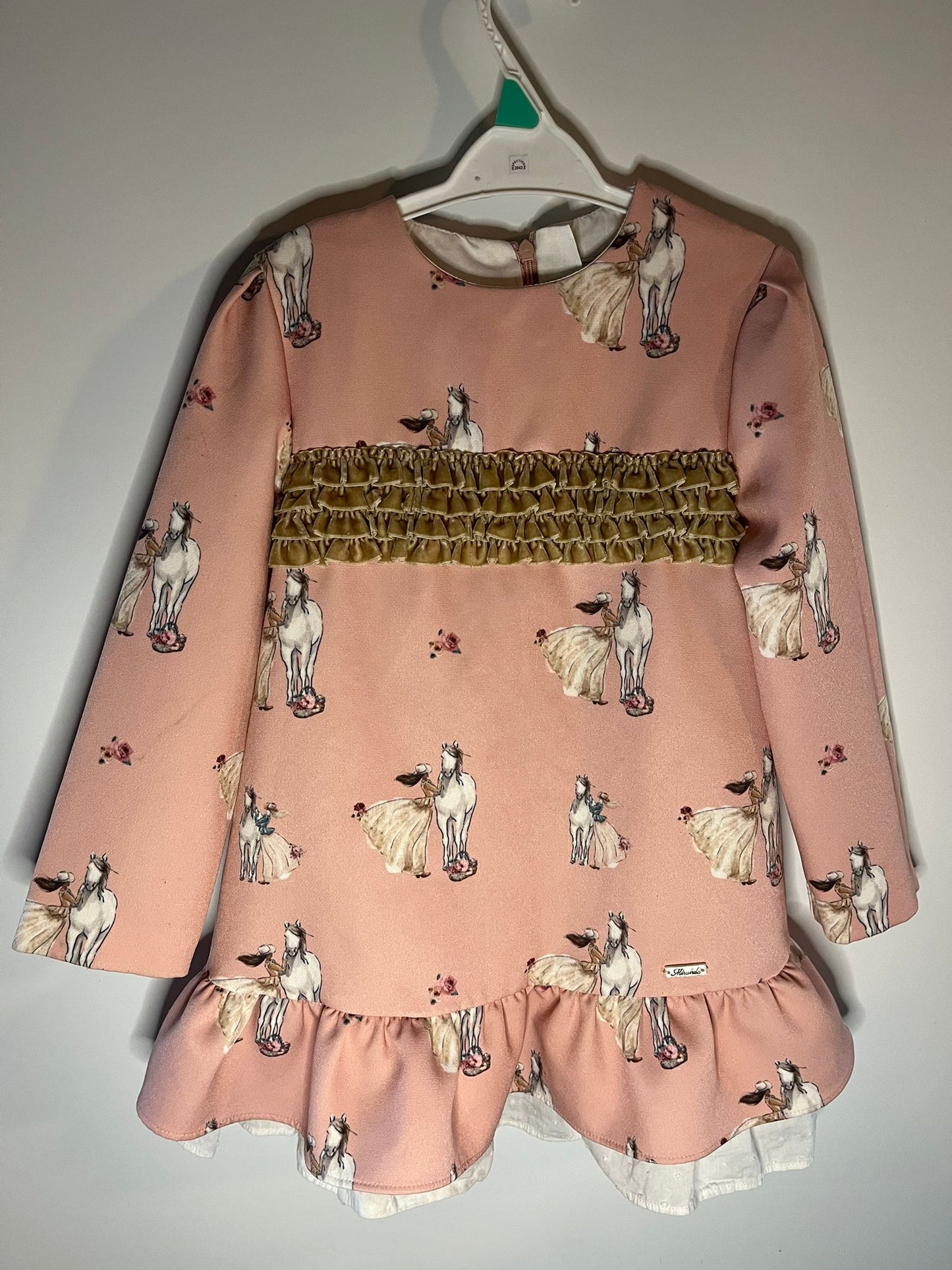 Pink dress with horse print on a hanger against a plain background, preloved little drums