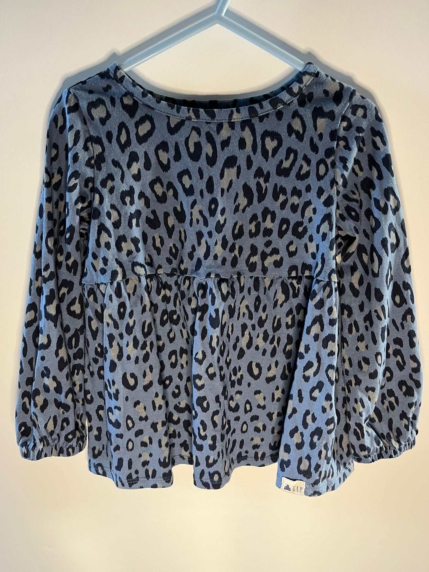 Blue leopard print top on a hanger against a white background. Preloved gap children top little drums