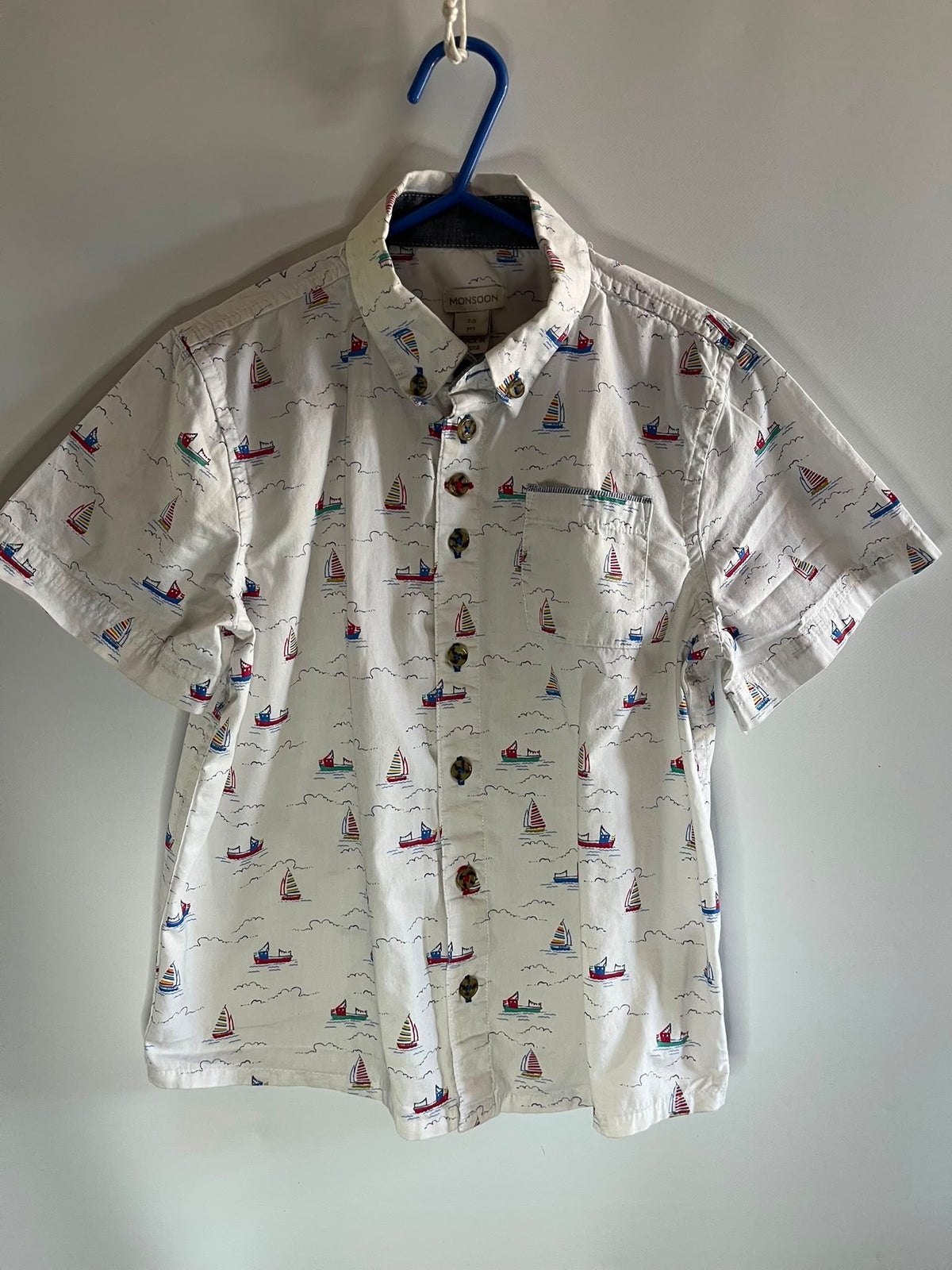 A short-sleeve button-up shirt with a white base and a colorful sailboat print, monsoon little drums
Preloved