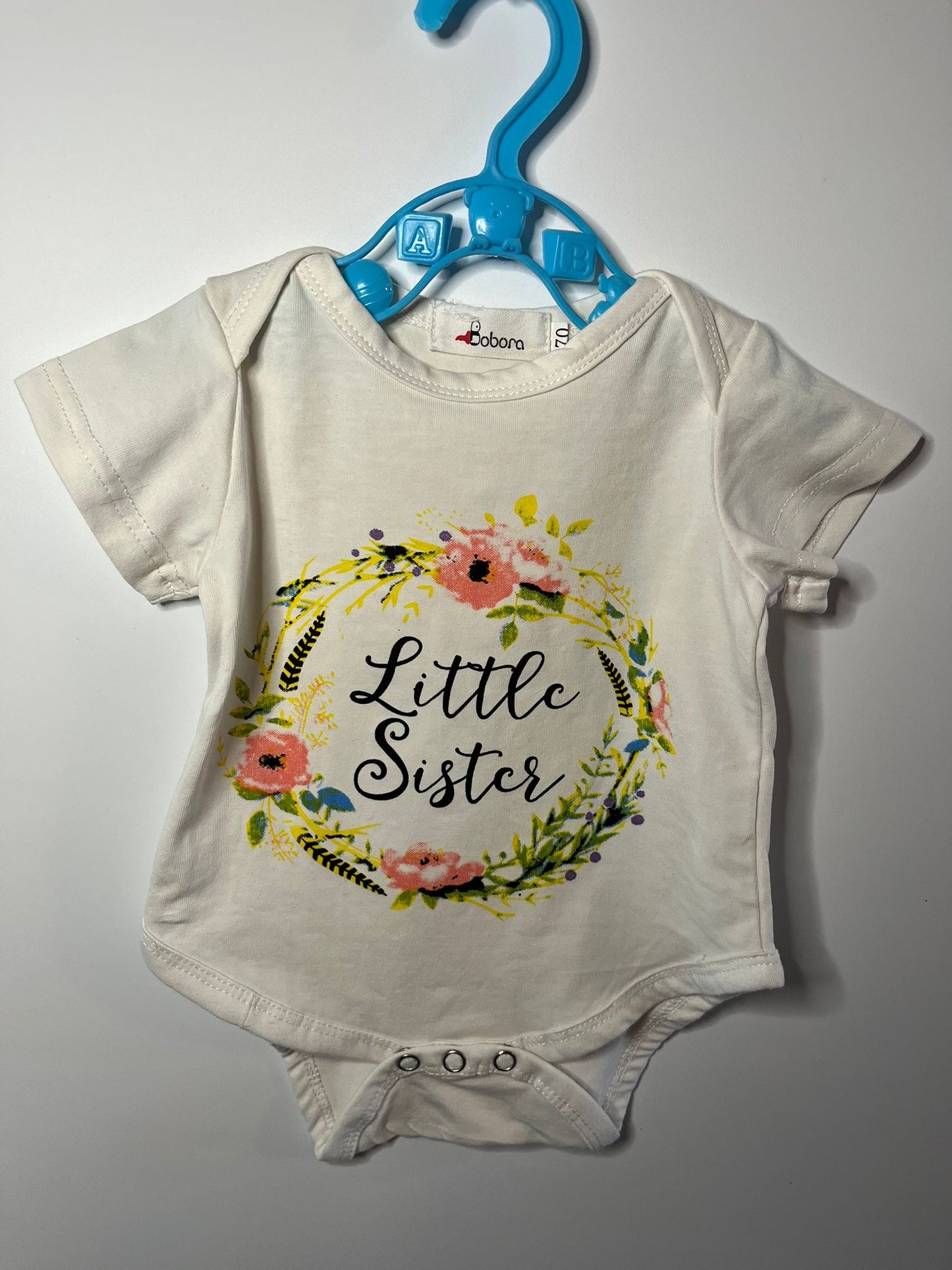 Baby vest with 'Little Sister' text and floral design, preloved little drums