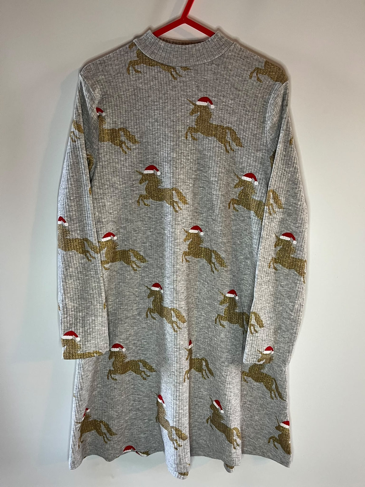 A gray ribbed knit long-sleeve tunic dress featuring an all-over pattern of unicorns wearing red and white Santa hats,