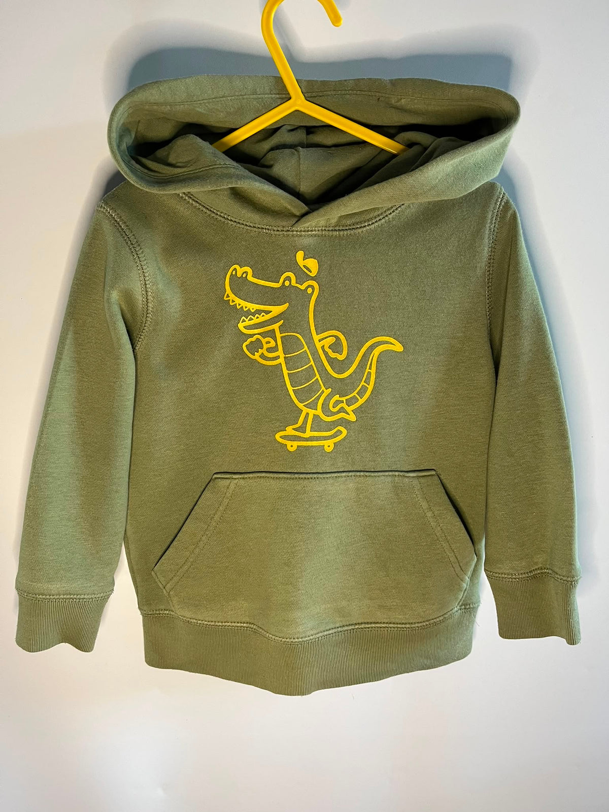An olive green kids' pullover hoodie with a yellow cartoon alligator graphic on the chest, gap size 3 years. Little drums, preloved clothing