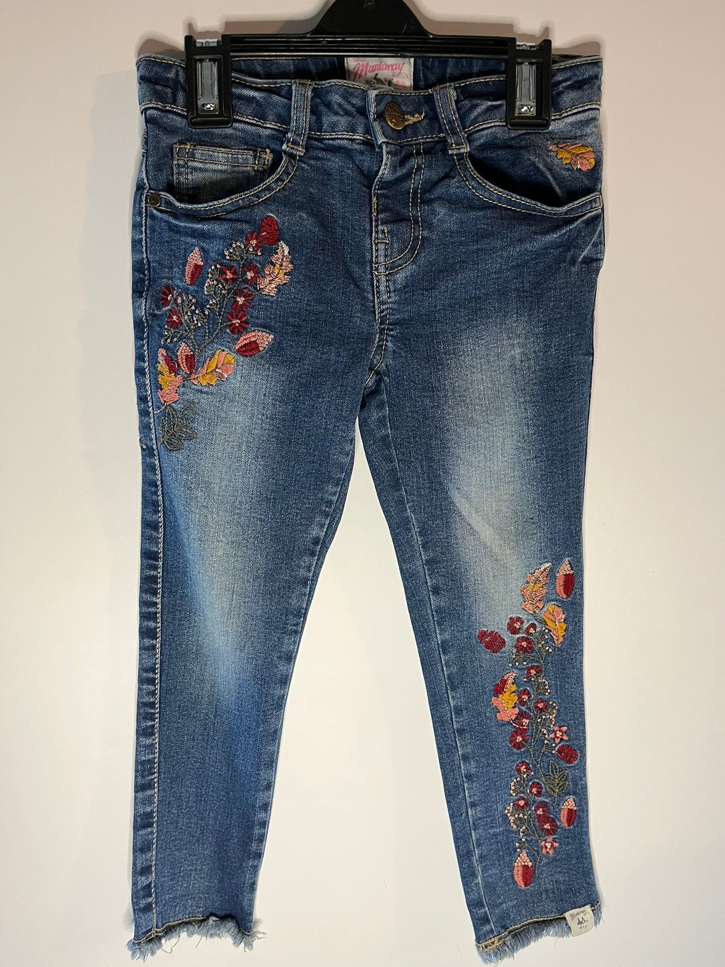 Blue jeans with floral embroidery on a white background, preloved little drums