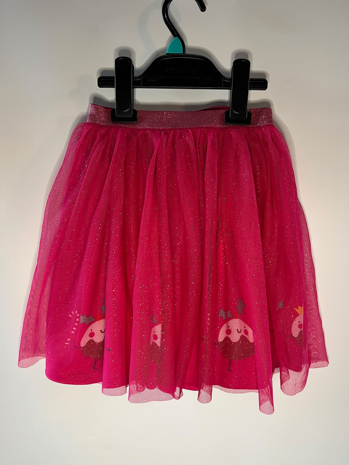 A bright pink tulle skirt with Christmas puddings. Size 5-6 years TU preloved little drums 