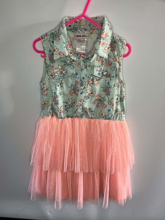A sleeveless children's dress. The top portion has a light green floral print with pink, orange, and blue flowers, and the bottom is a layered peach-pink tulle tutu skirt.