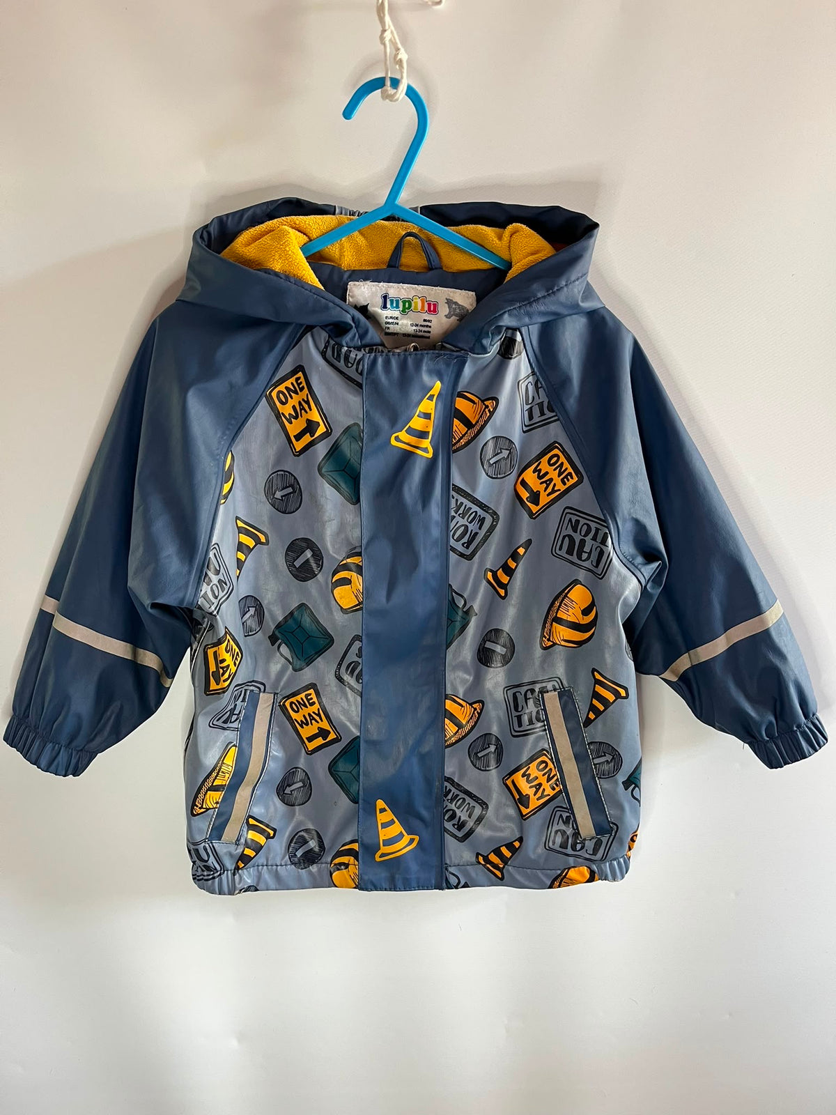 A kids' hooded rain jacket in blue with a yellow and gray construction-themed print, preloved little drums children clothing 
