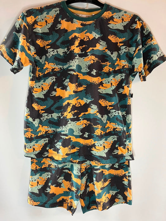 A two-piece short-sleeve pajama set consisting of a crewneck t-shirt and matching shorts, both featuring a distressed camouflage pattern in orange, teal green, black, and light gray, next size 9 years preloved little drums 