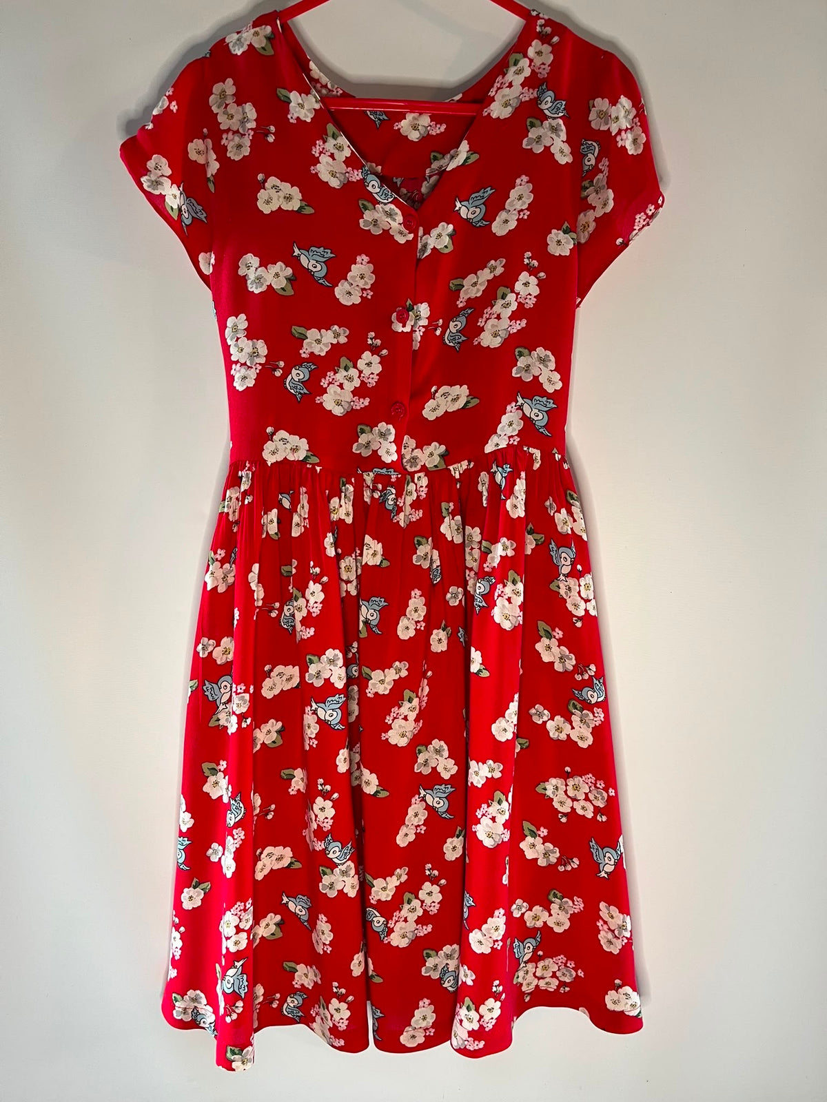 A red short-sleeve V-neck dress with a white and blue floral print, Cath Kidson preloved little drums 