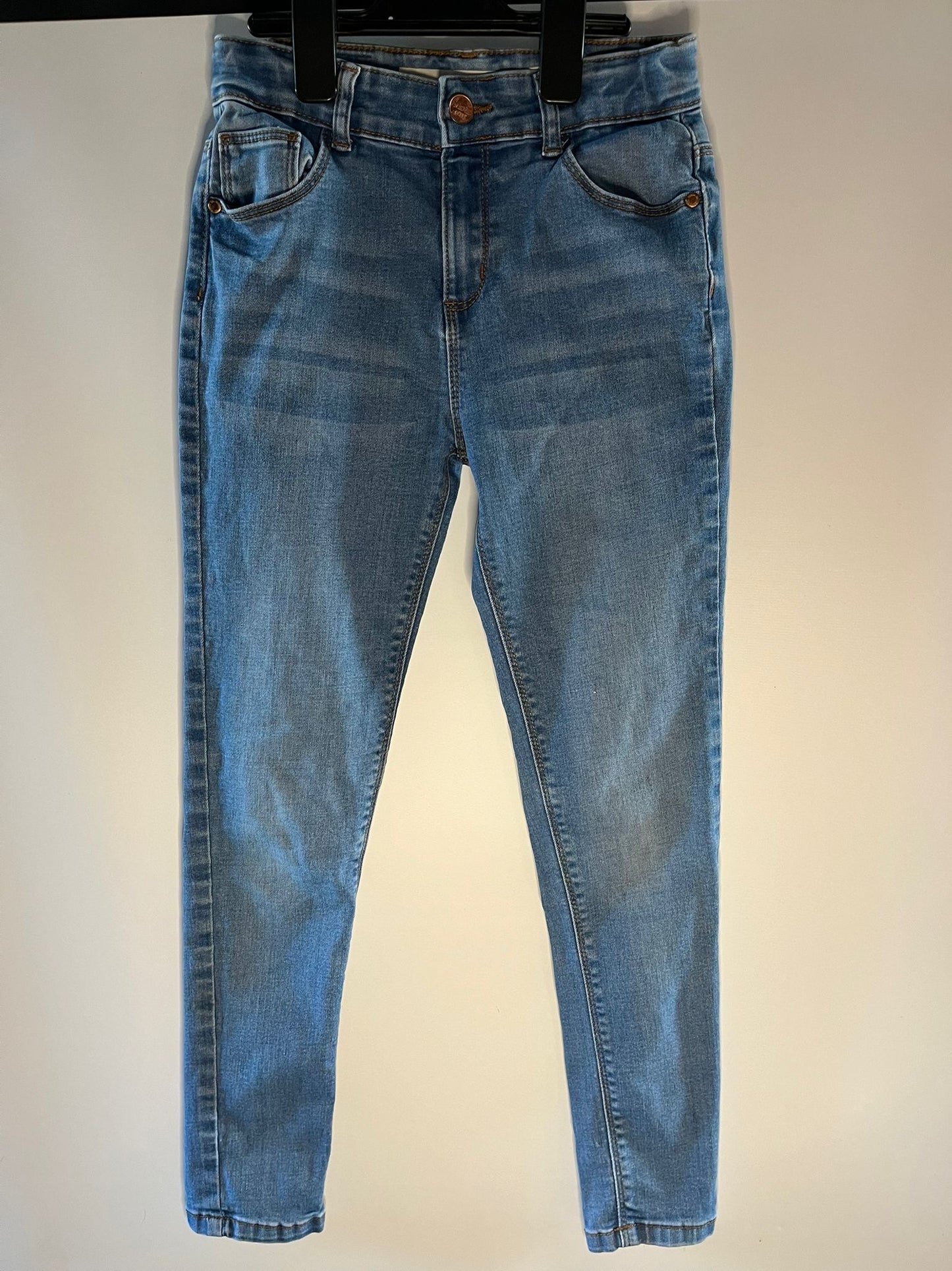 Pair of blue jeans on a white preloved children clothing little drums 