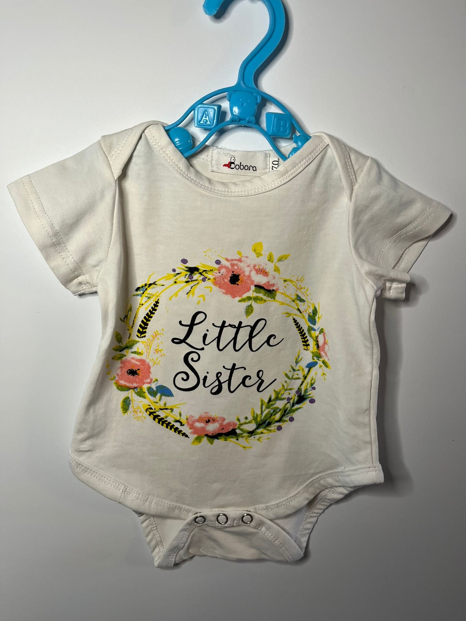Baby vest with 'Little Sister' text and floral design, preloved little drums