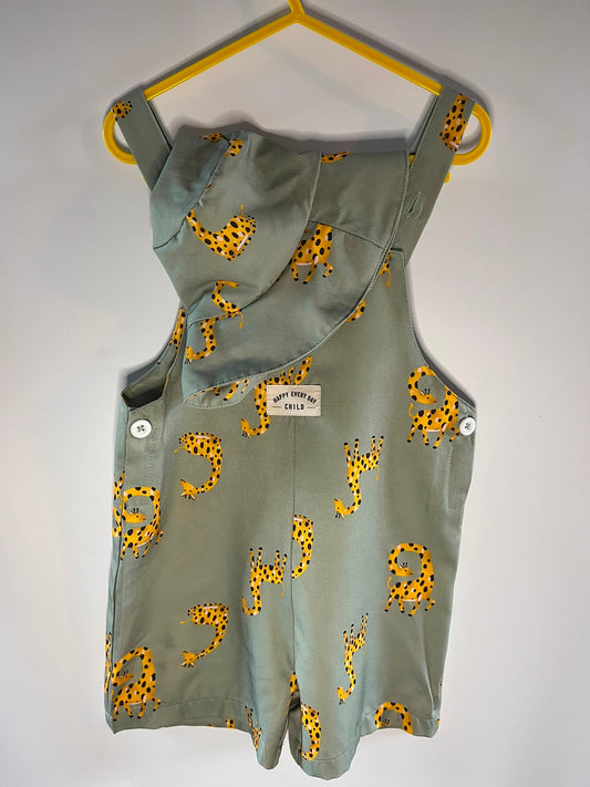 A sage green sleeveless romper with a yellow and black giraffe print, SHEIN preloved 