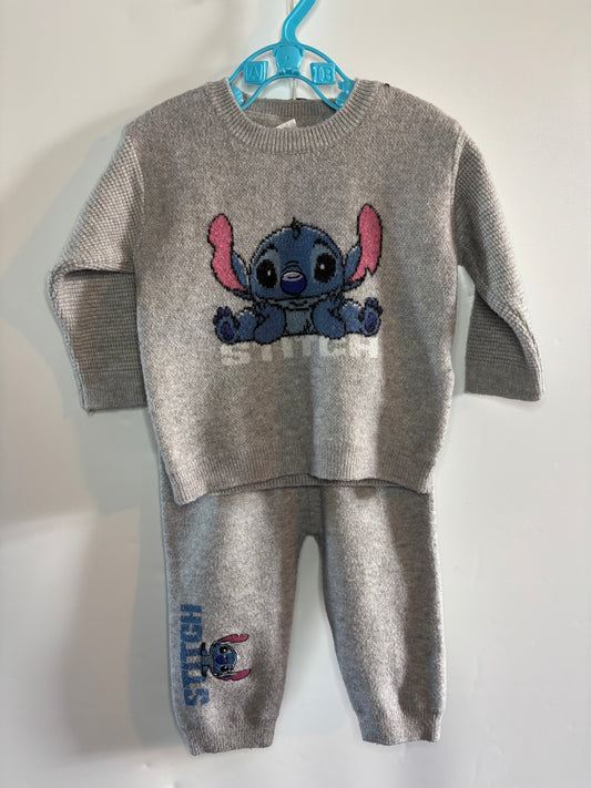 A children's two-piece knit loungewear set in heather gray, featuring a long-sleeve top with a large Stitch graphic on the chest and matching jogger pants with a vertical Stitch print. The set is displayed on a blue plastic hanger against a plain white wall.
