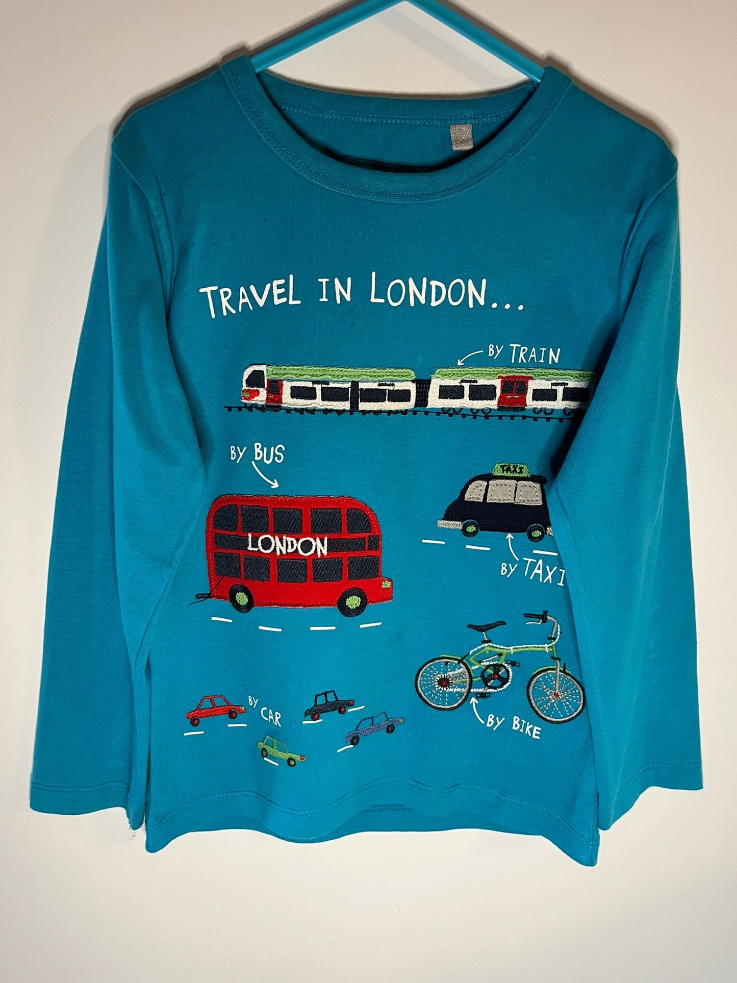 Blue long-sleeve shirt with London-themed graphics on a white background