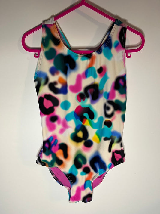 Colorful leopard print swimsuit on a pink hanger against a white background