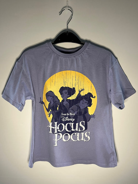 Gray t-shirt with 'Hocus Pocus' graphic on a hanger against a plain background
