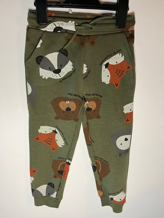 Green children's pants with animal pattern on a white background