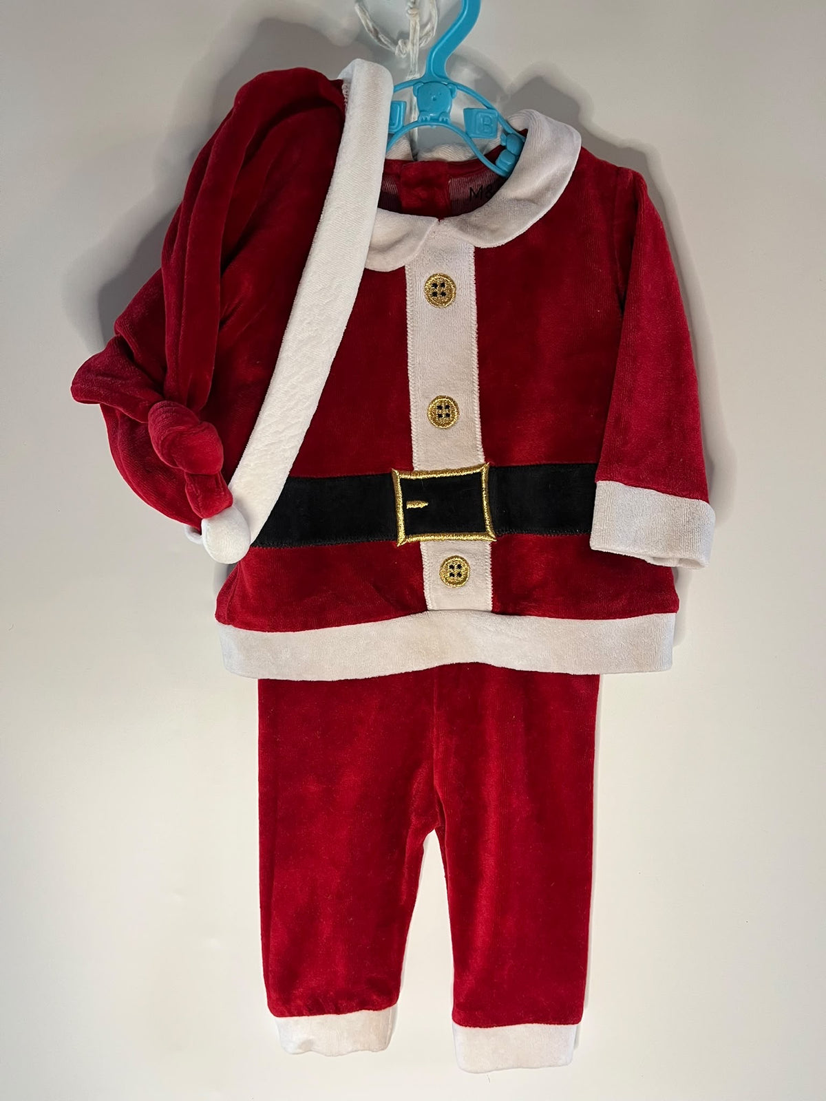 A baby Santa Claus costume set in red plush velvet with white faux fur trim, a black belt, and gold-tone buckle,