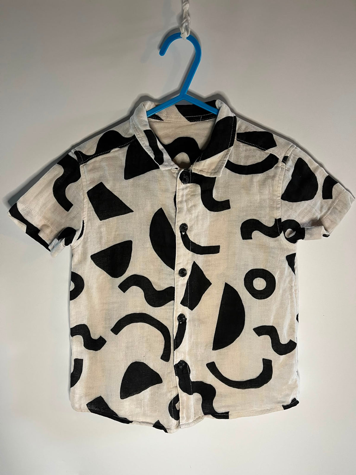 A short-sleeve button-up shirt with an abstract black and off-white pattern, George preloved little drums 