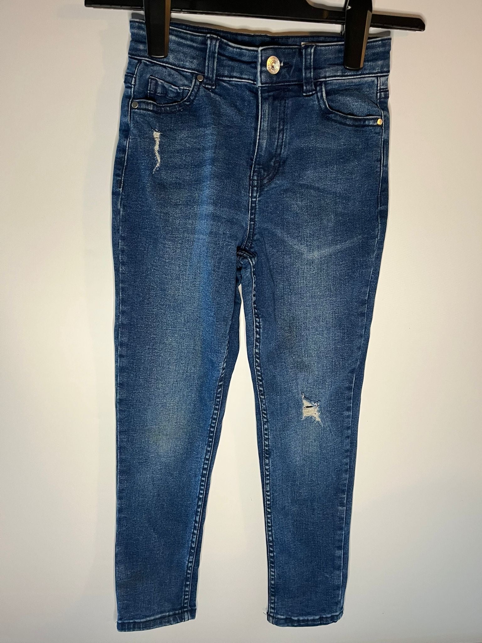 Blue jeans with slight distressing on a white background next, preloved little drums