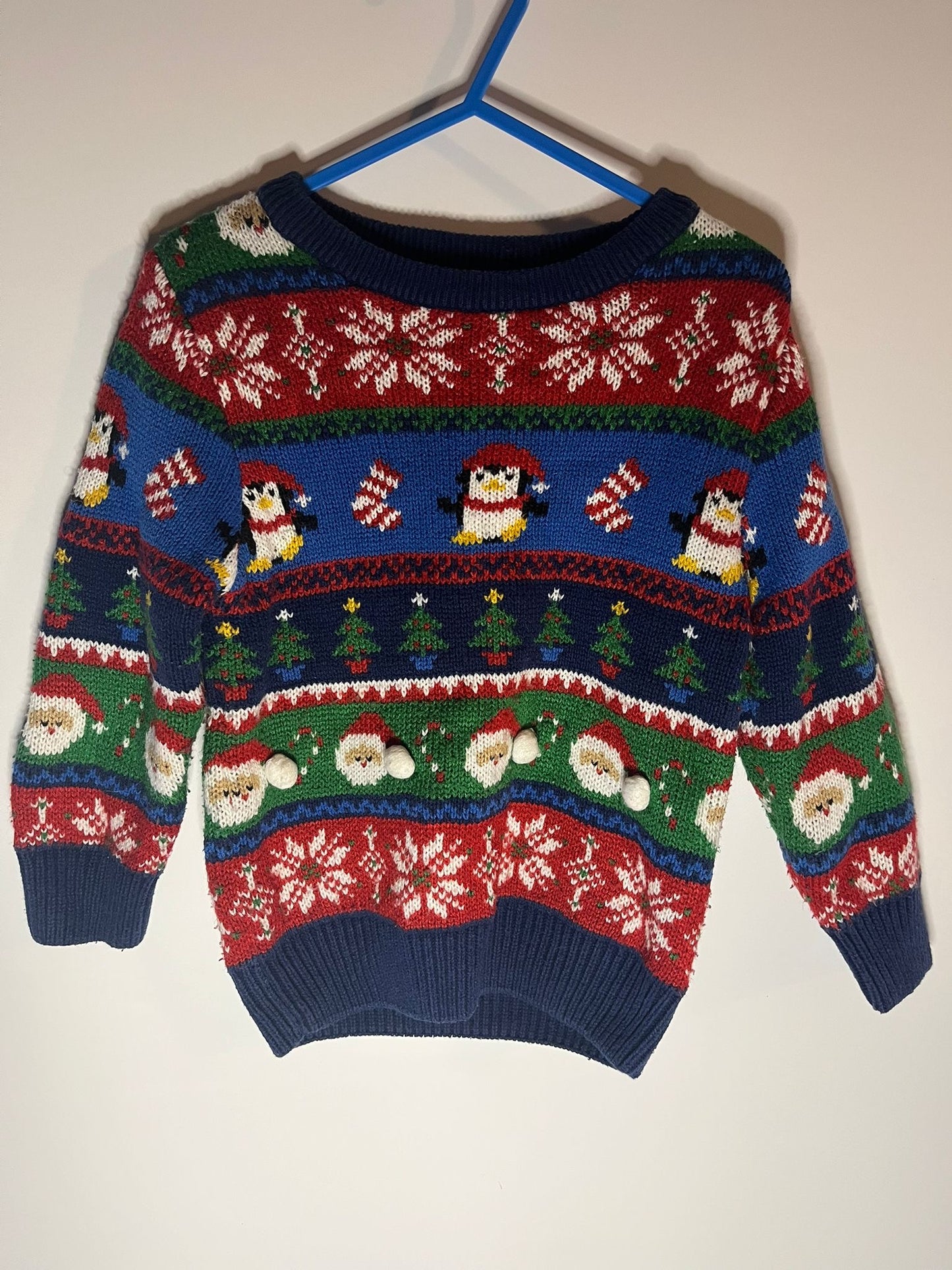 Colorful Christmas-themed sweater with penguins and Santa Claus from George, preloved little drums